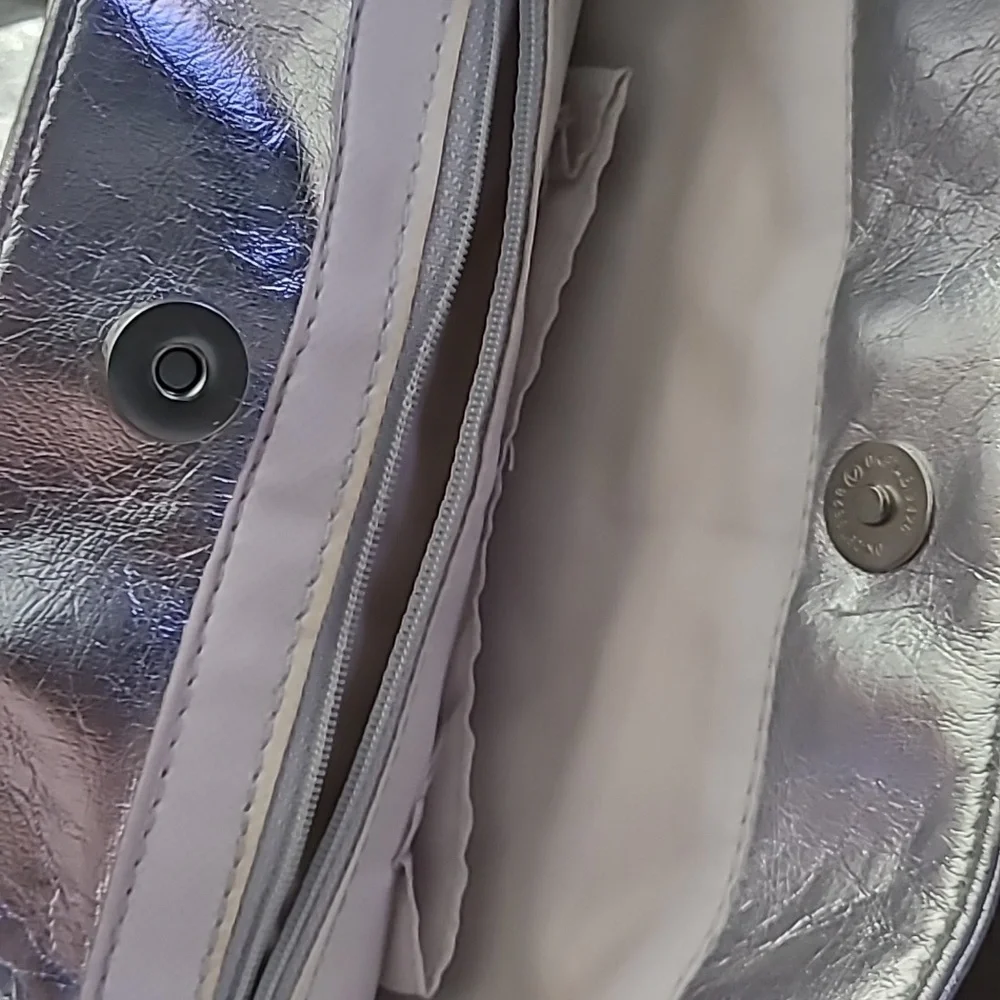 Shiny silver metallic handbag. Outside pockets snap closure‎ clean inside